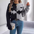 Women’s two-tone black and grey knit sweater with zigzag graphic, relaxed fit, paired with blue jeans.