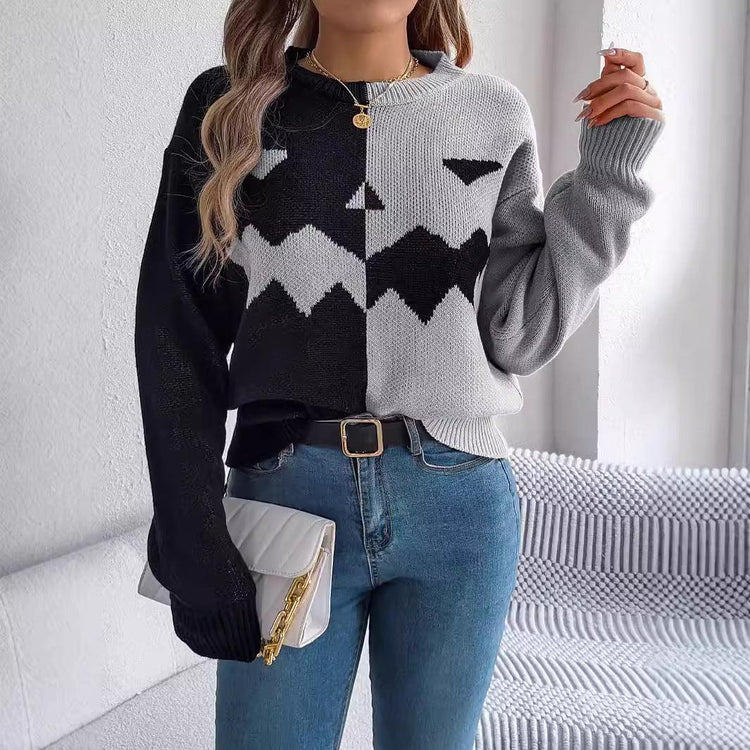 Women’s two-tone black and grey knit sweater with zigzag graphic, relaxed fit, paired with blue jeans.