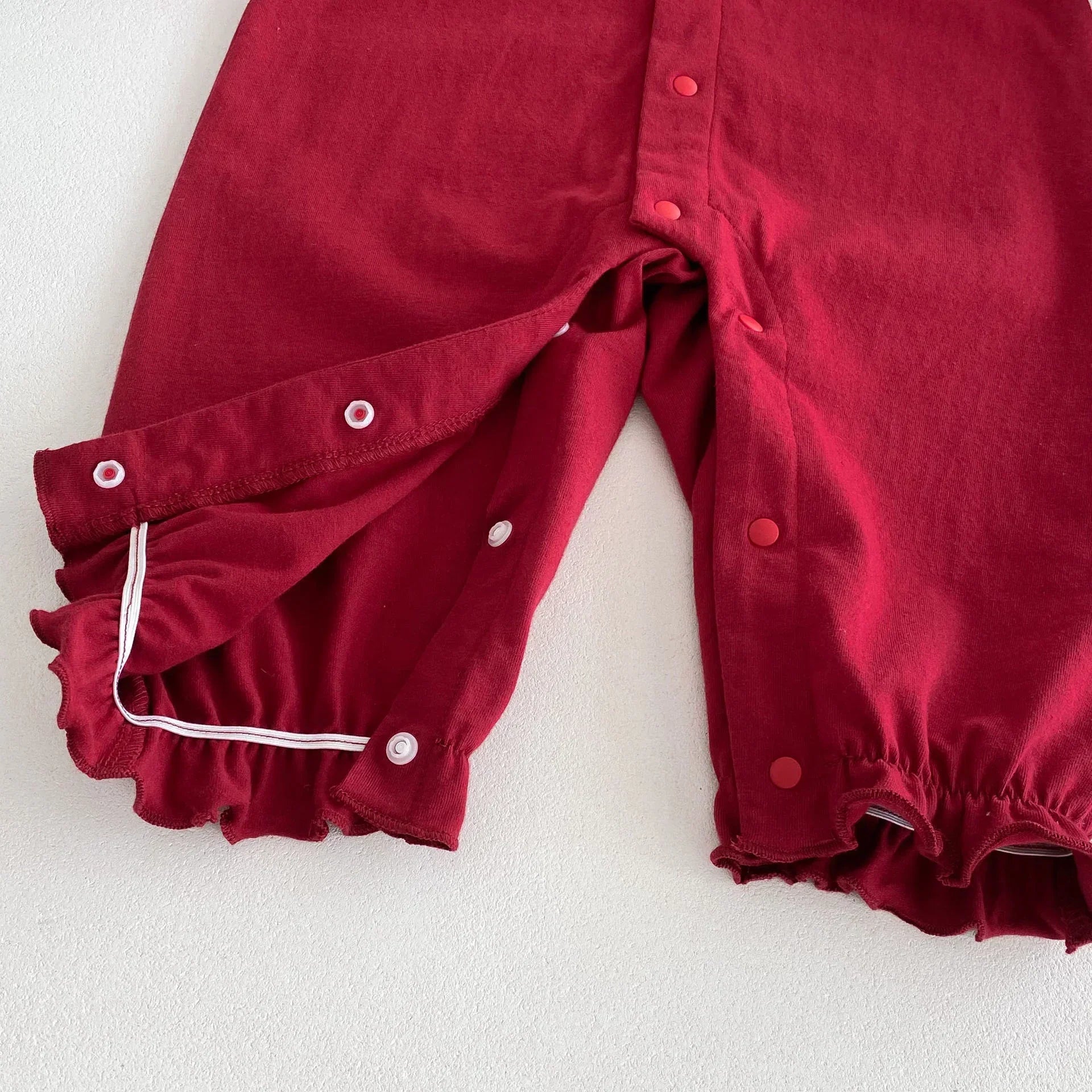 Red cotton pants with snap buttons and elastic cuffs, relaxed fit streetwear style