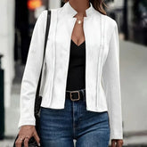 Woman wearing a fitted white suede jacket over a black top and blue jeans, casual street style