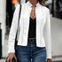 Woman wearing a fitted white suede jacket over a black top and blue jeans, casual street style