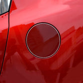 Close-up of red metallic car fuel tank door with glossy finish