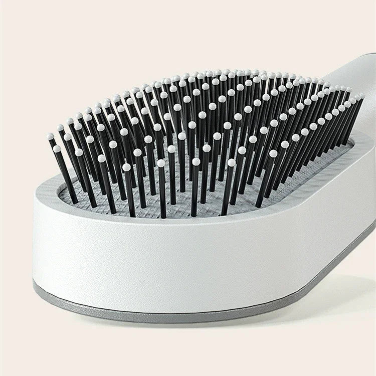 Close-up of a modern white and gray hairbrush with black bristles and rounded tips