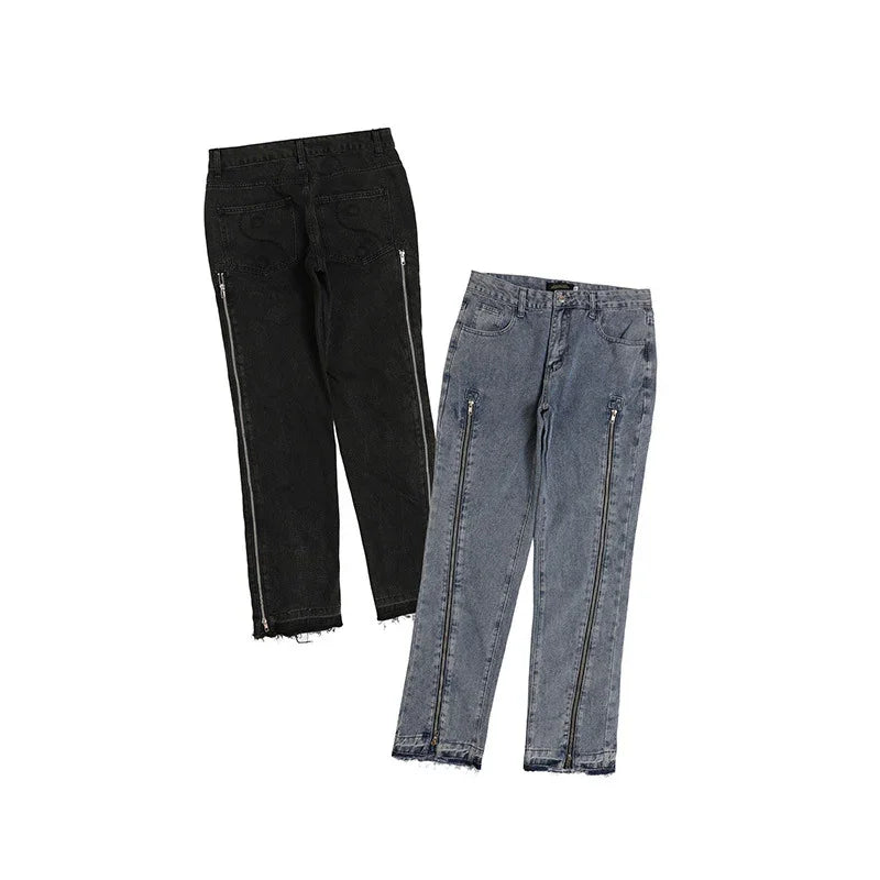 Black and gray straight-leg jeans with full-length side zippers and raw hem details