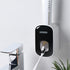 Wall-mounted automatic toothpaste dispenser in black and white plastic, modern bathroom setting