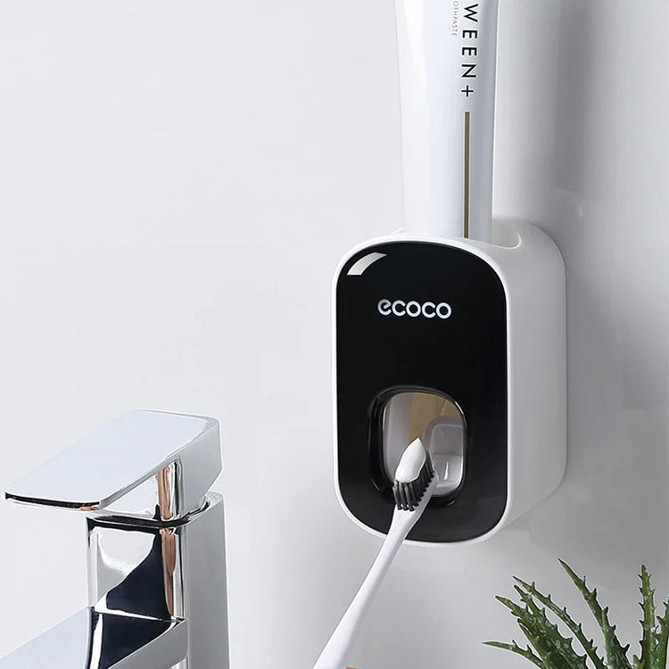 Wall-mounted automatic toothpaste dispenser in black and white plastic, modern bathroom setting