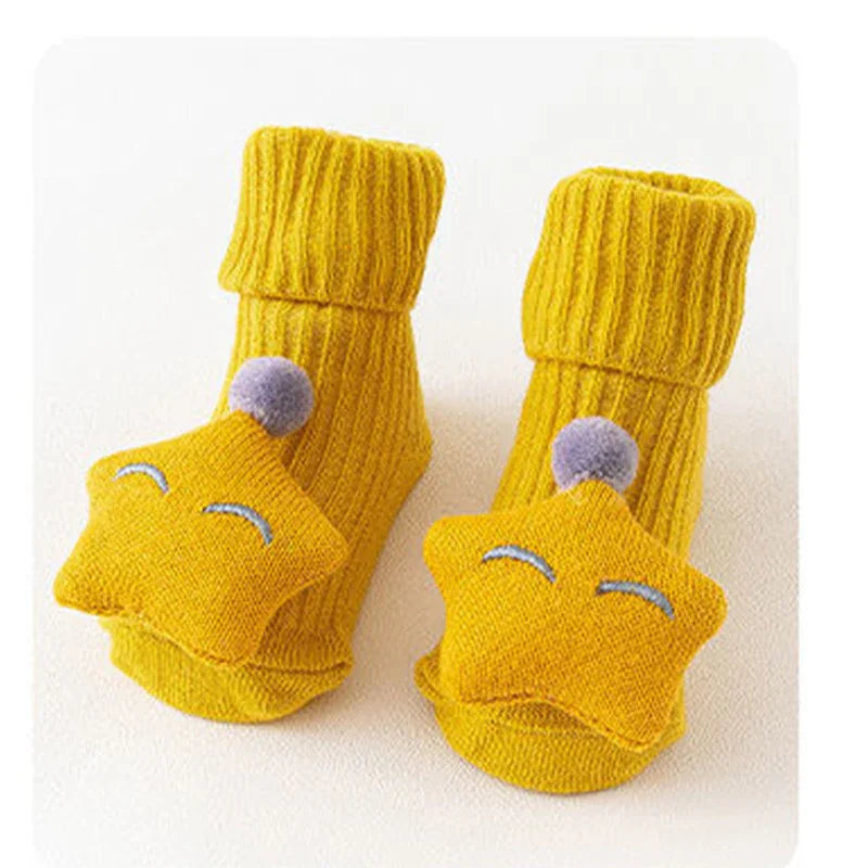 Yellow ribbed knit baby socks with soft star and pompom details, cozy fit.