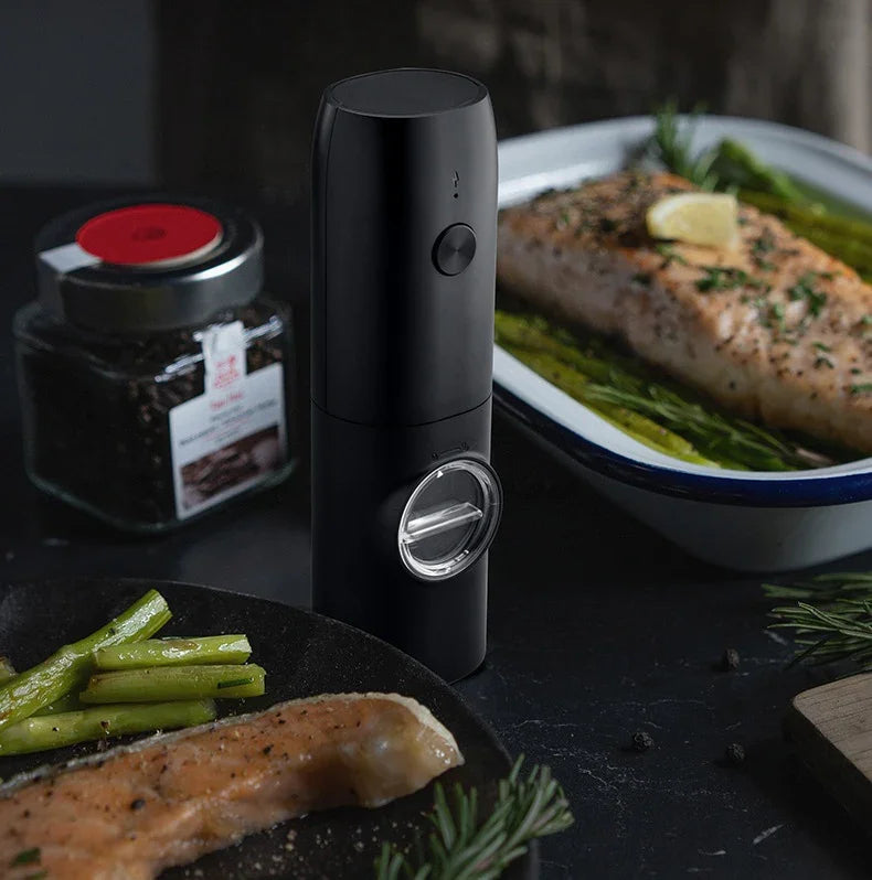 Sleek black electric grinder on kitchen counter beside seasoned salmon and asparagus
