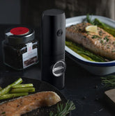 Sleek black electric grinder on kitchen counter beside seasoned salmon and asparagus
