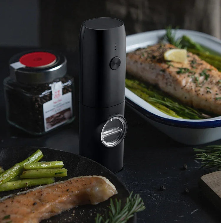 Sleek black electric grinder on kitchen counter beside seasoned salmon and asparagus