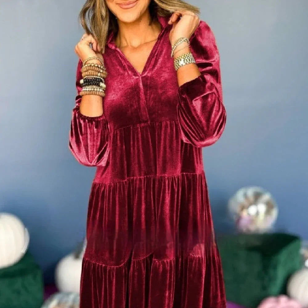 Woman wearing a loose-fit tiered burgundy velvet dress with long sleeves