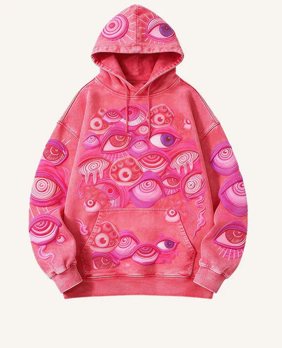 Oversized pink streetwear hoodie with abstract eye graphics and drawstring hood, cotton material.