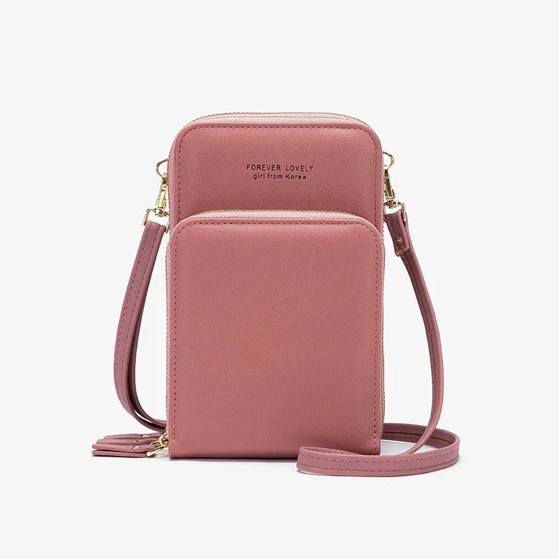 Pink faux leather crossbody bag with front pocket and gold zipper detailing