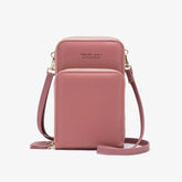 Pink faux leather crossbody bag with front pocket and gold zipper detailing