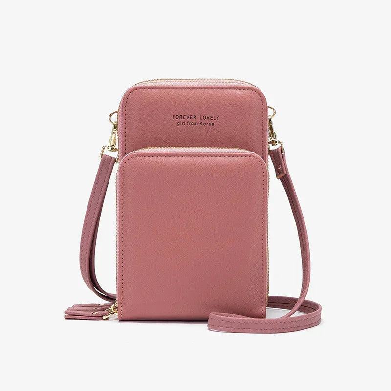 Pink faux leather crossbody bag with front pocket and gold zipper detailing