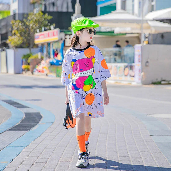 Kid wearing oversized graphic streetwear t-shirt dress with neon colors, orange socks, and green cap
