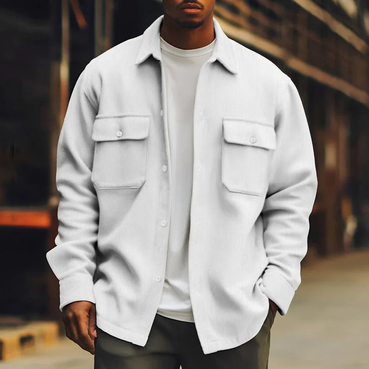 Man wearing a white oversized button-up shirt jacket with chest pockets, casual streetwear style