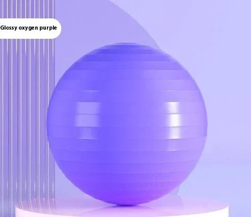 Glossy purple exercise yoga ball on a modern minimalistic display stand.