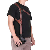 Man wearing a brown leather camera harness with adjustable straps, casual black t-shirt