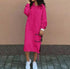 Woman wearing a bright pink oversized hoodie dress with long sleeves and white sneakers