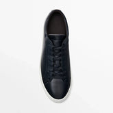Black leather low-top sneaker with white sole, minimalist streetwear shoe design