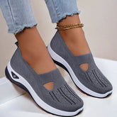 Gray slip-on knit sneakers with cutout design, white soles, and a relaxed fit