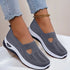 Gray slip-on knit sneakers with cutout design, white soles, and a relaxed fit