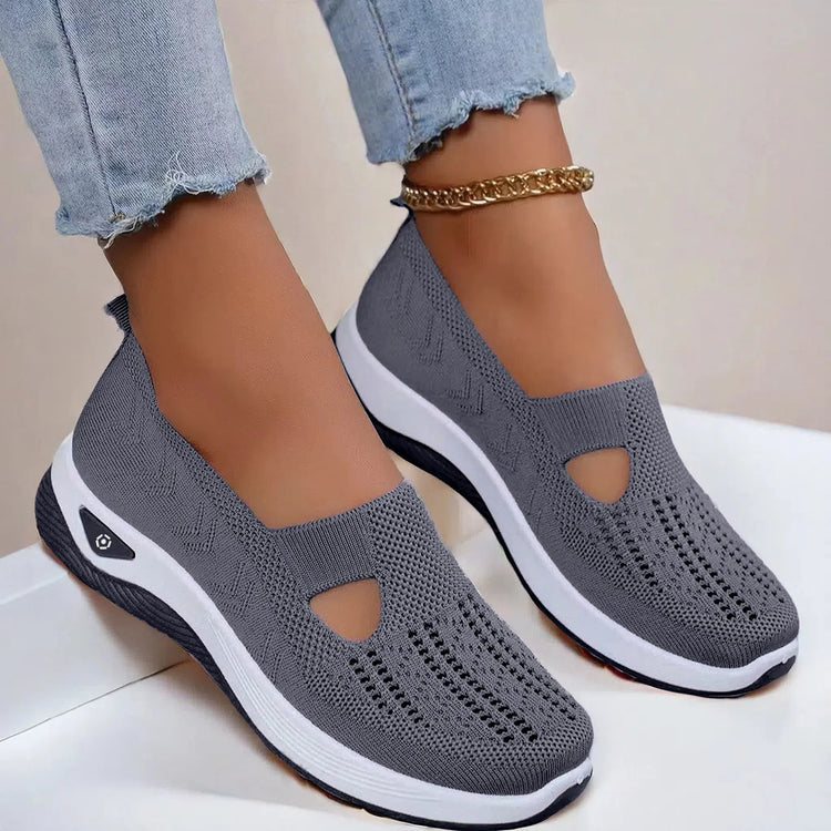 Gray slip-on knit sneakers with cutout design, white soles, and a relaxed fit