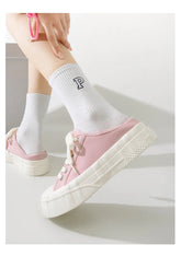 Light pink canvas sneakers with thick white soles, paired with white ribbed socks.