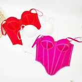 Three structured bustier tops in red, white, and hot pink with bold seams, sleeveless, fitted style.