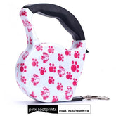 White retractable dog leash with pink paw prints and cartoon dog faces, black handle
