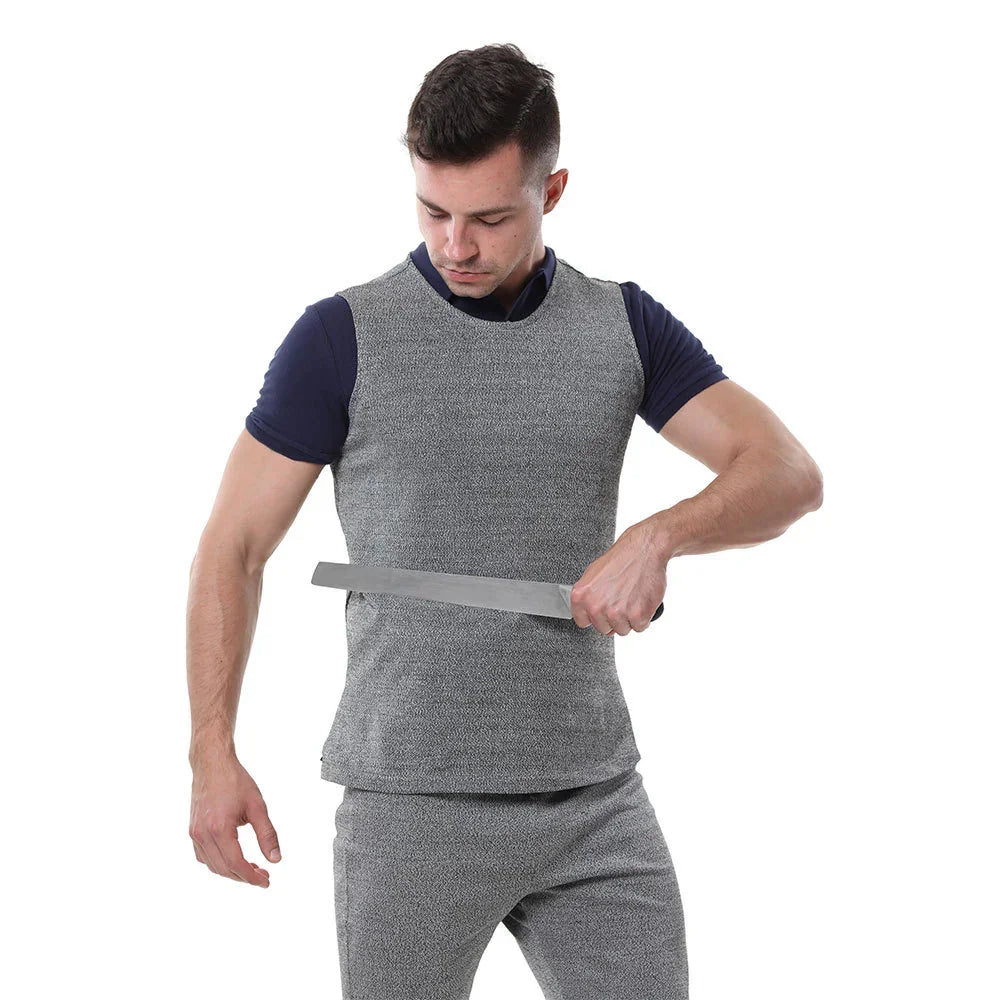 Man wearing grey, fitted, sleeveless protective vest over navy shirt, matching grey pants