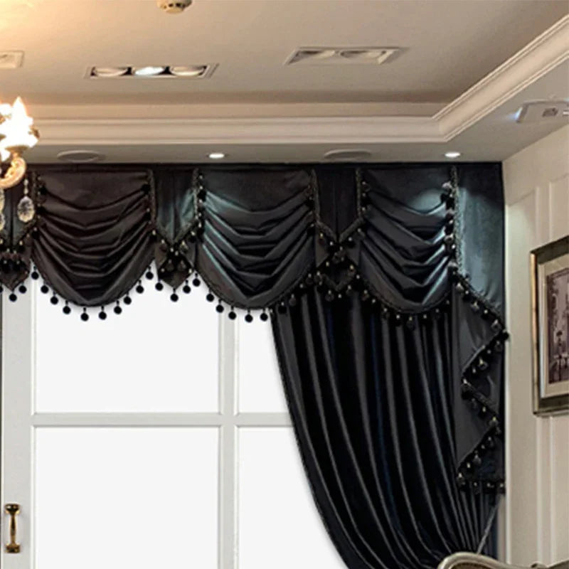 Elegant black velvet curtains with swag valance and decorative tassels in a modern living room