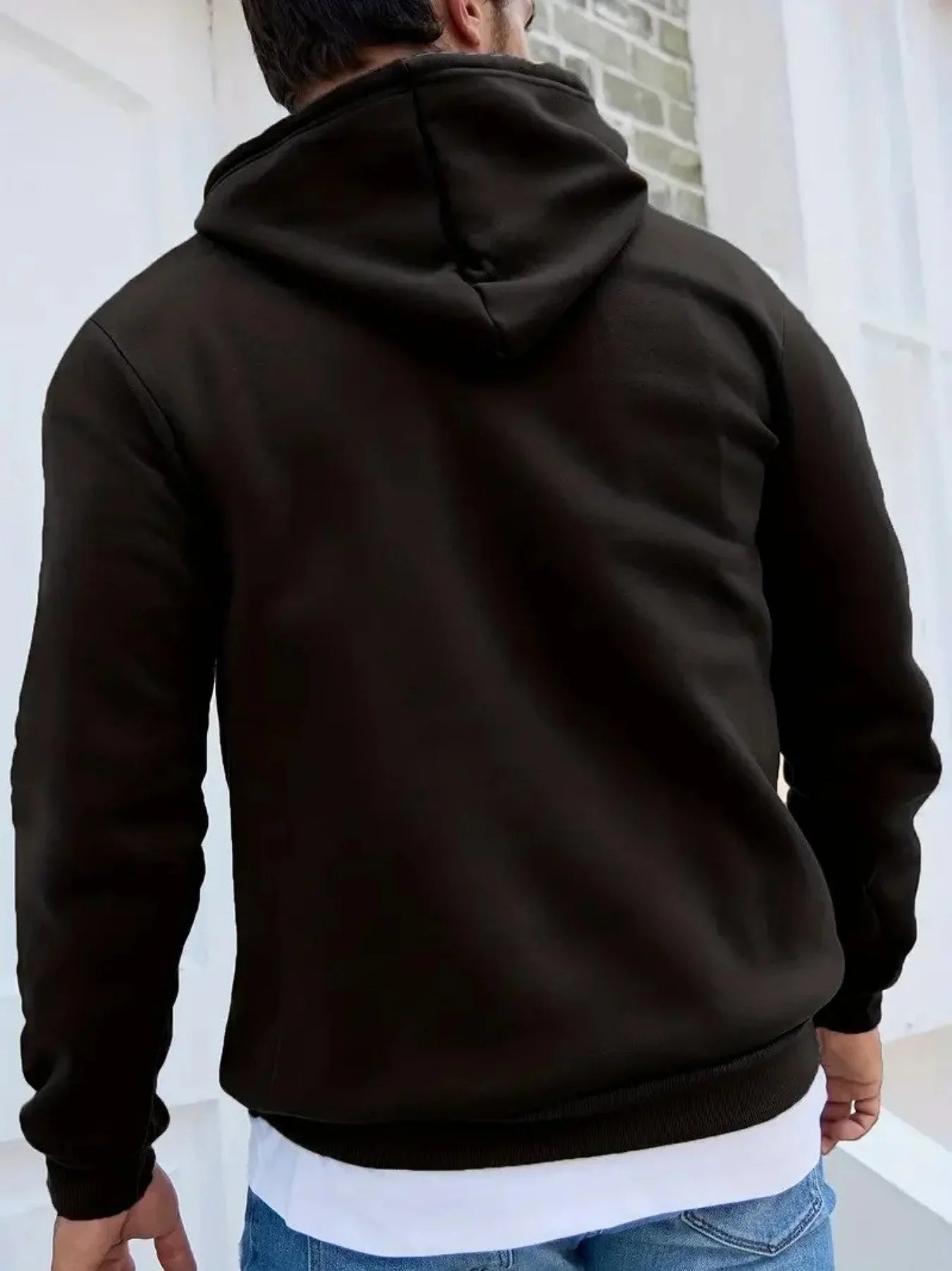Man wearing a black hooded sweatshirt with relaxed fit and soft fabric, casual streetwear style