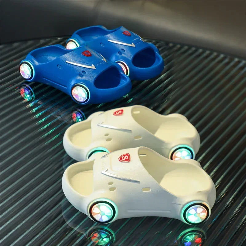 Blue and white car-shaped slippers with light-up wheels, made of soft foam material