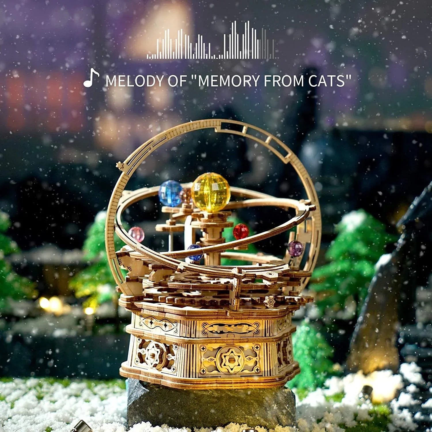 Intricate wooden mechanical model with colorful spheres, displayed on a snowy background