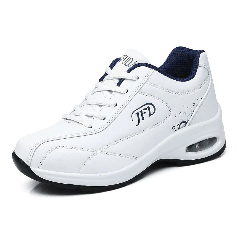 White athletic sneaker with air-cushioned sole, lace-up design, and navy mesh lining.
