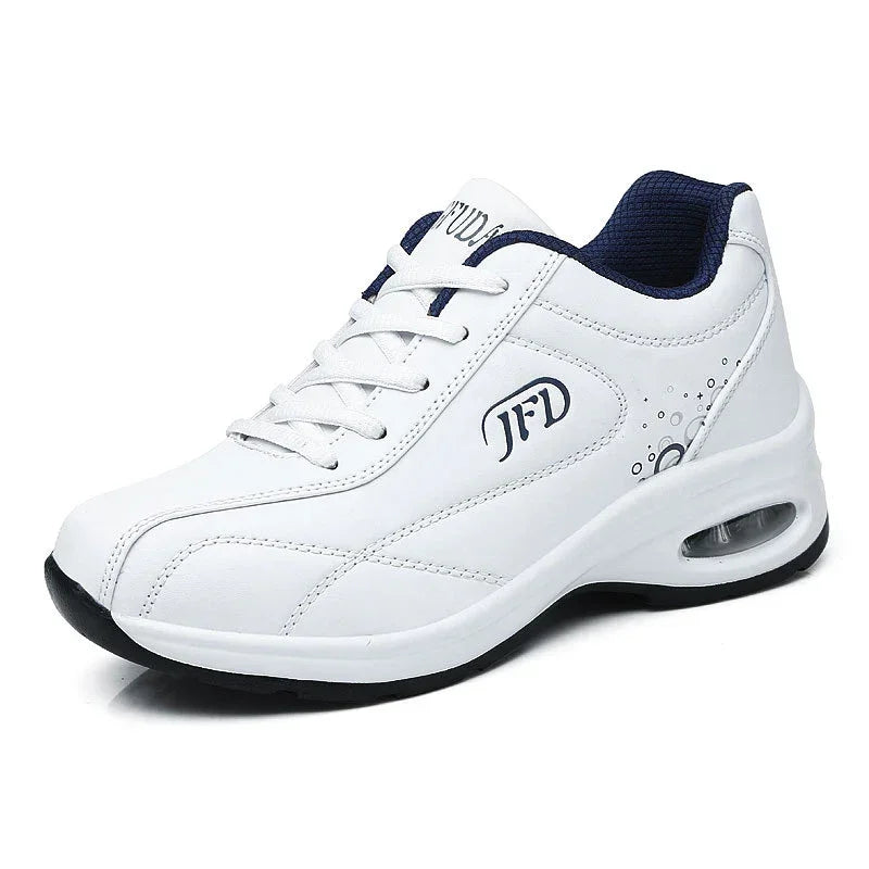 White athletic sneaker with air-cushioned sole, lace-up design, and navy mesh lining.