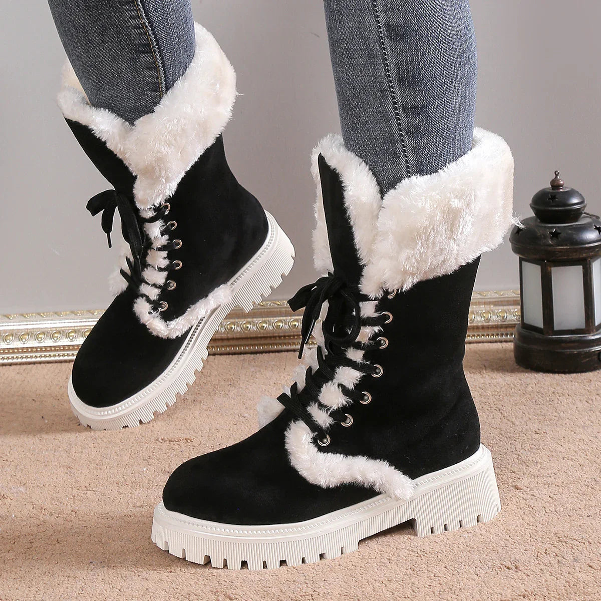 Black faux fur lined winter boots with chunky white sole and lace-up design, styled with skinny jeans.