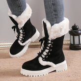 Black faux fur lined winter boots with chunky white sole and lace-up design, styled with skinny jeans.