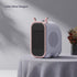Compact modern space heater in pastel pink and grey, rounded design, sits on textured tablecloth.