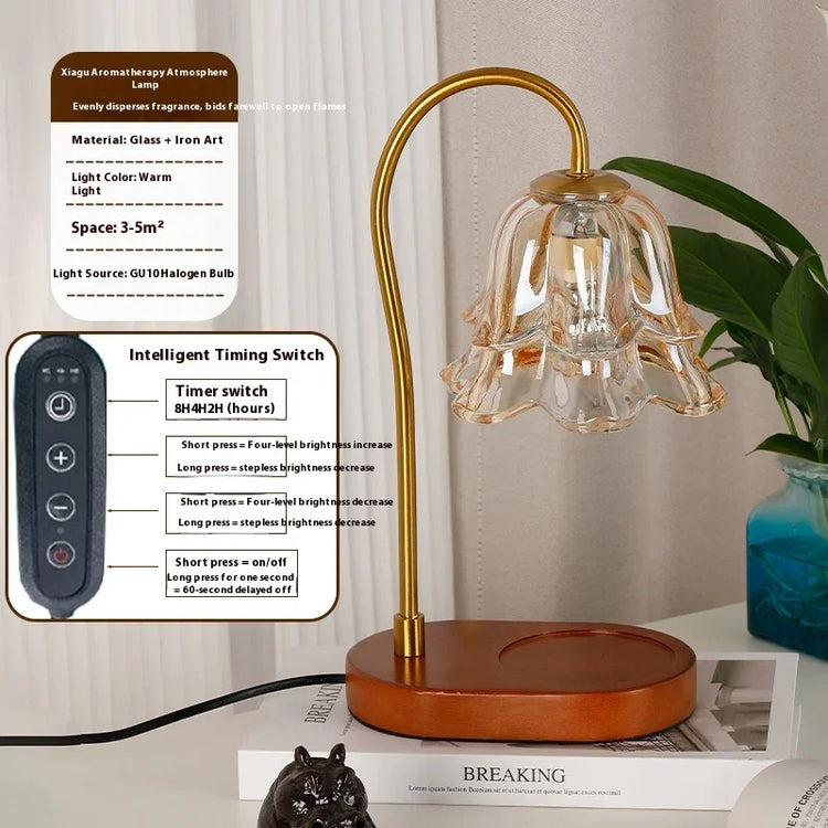 Modern gold and glass flower-shaped aromatherapy lamp with remote control on a wooden base.