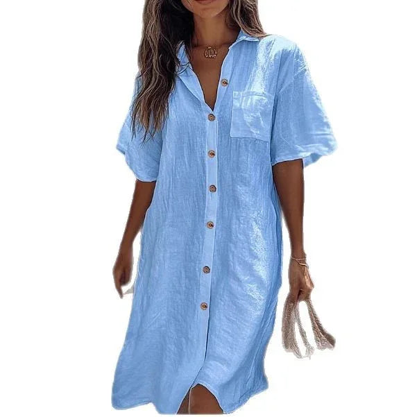 Woman wearing light blue linen button-down shirt dress with short sleeves and relaxed fit