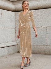 Woman wearing a beige velvet wrap midi dress with puff sleeves and a fitted waist.