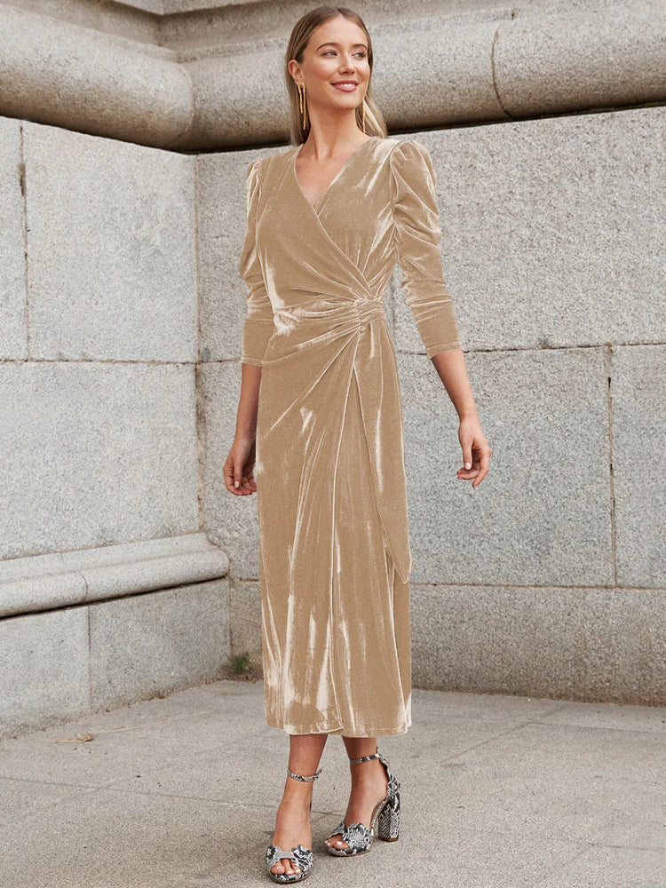 Woman wearing a beige velvet wrap midi dress with puff sleeves and a fitted waist.