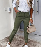 Woman wearing olive green slim-fit jogger pants, white button-up shirt, and white sneakers