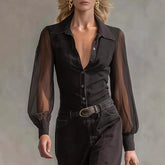 Woman wearing sheer long sleeve black button-up blouse with fitted waist and black pants