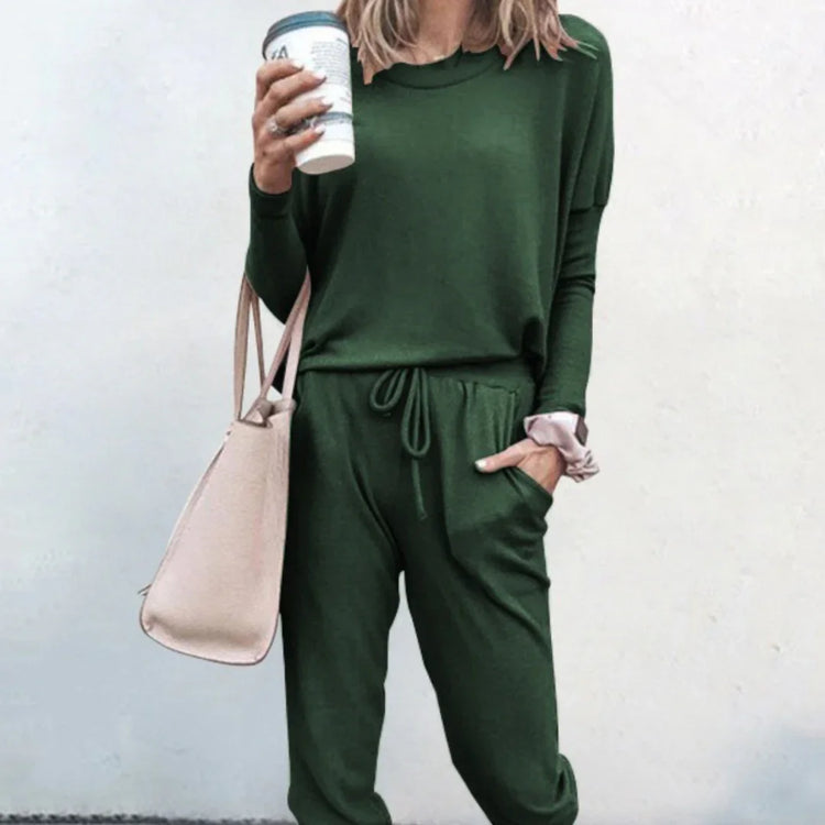 Woman in a green long-sleeve jogger set, relaxed fit, soft fabric, holding a pink tote bag