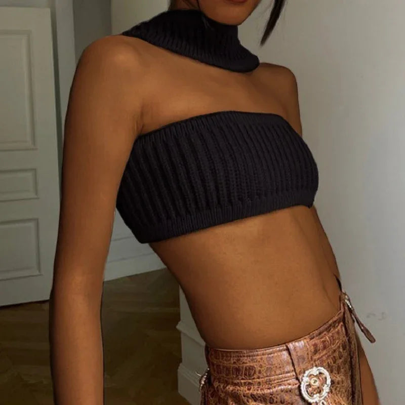 Woman wearing black ribbed knit bandeau crop top with matching choker and brown faux leather skirt