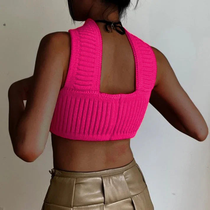 Back view of a woman wearing a hot pink ribbed knit crop top and high-waisted tan pants